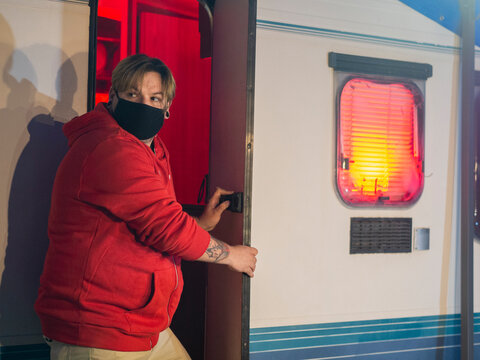 Hombre entrando en su autocaravana durante la noche de halloween, usando mascarilla para protegerse de la pandemia del coronavirus