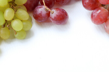 Top view. Grapes on white background. Grapes with copy space for text. Red and green grapes. Vegetarian or healthy eating.