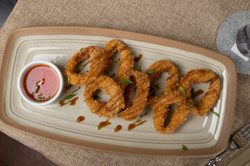 Deep fried squid rings with tomato sauce on the table at restaurant