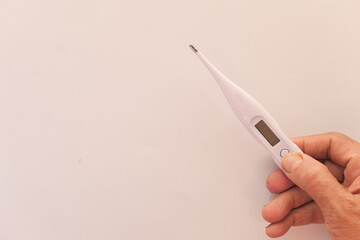 senior women hand holding digital thermometer, top view .