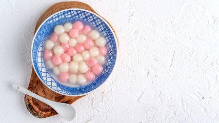 Top view of red and white tangyuan in blue bowl on white background for Winter solstice.