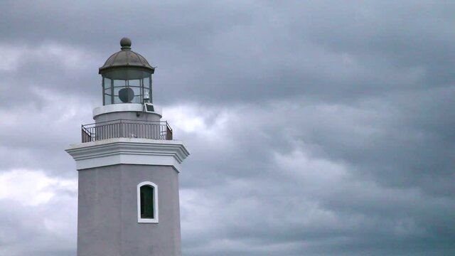 An old lighthouse in a grey cloudy thunderstorm, on a coast in Puerto Rico.