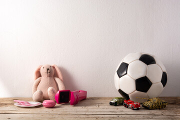 Gender stereotype toys on wooden table and white background