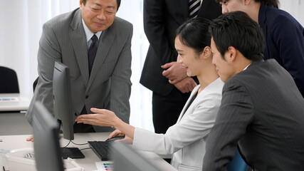 パソコンを見て話し合うビジネスマン