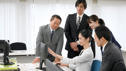 パソコンを見て話し合うビジネスマン