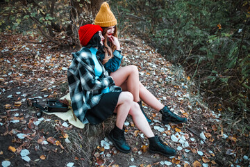 Elegant and stylish girls sitting in a autumn park 