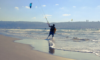 Man engaged kitesurfing on Sunny summer beach. Israel. Kiryat Yam. Haifa
