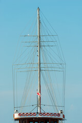 Mast of a ship without sails close up on sky background