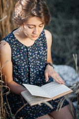 girl reading a book in a wheat field
