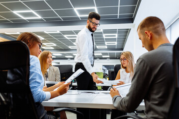 group of young leaders sitting at their desk discussing planning the next steps of work