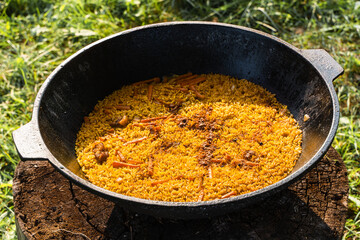Freshly cooked pilaf in a big metal cauldron.