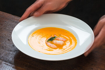 Butternut squash cream soup plate woman hands.