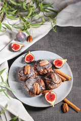 chocolate muffins with pecan and figs on gray background