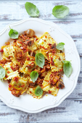 Ravioli with mushrooms and fresh basil. Bright wooden background. Top view.	