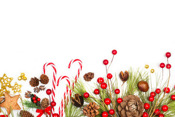 Composición de Navidad con ramas de abeto, bastones de caramelos, acebo, piñas y estrellas sobre...