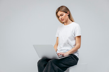 Naklejka premium Modern Girl with laptop in studio. Free creativity