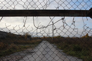 fence with a grid made of metal torn lattice forbidden territory of the zone