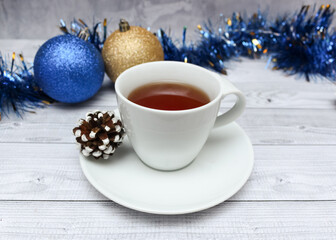 White cup of tea on background, christmas ball, home comfort concept.