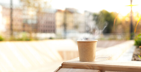 Cardboard cup with hot coffee on wood in urban area.
Kartonbecher mit heißem Kaffee auf Holz in...
