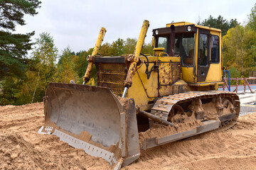 Obraz na płótnie Canvas Dozer at road construction and bridge projects in forest area. Heavy machinery for road work. Building a road works. Bulldozer on leveling and compaction of ground