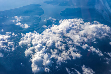 Aerial view of land and blue sea from airplane window