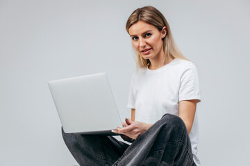 Modern Girl in white t-shirt with laptop in studio. Free creativity