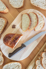 Top view homemade sliced breads and knife on wooden table in kitchen. Homemade healthy food concept.