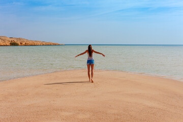 Tourist woman at the Red Sea coast in the Ras Mohammed National Park. Famous travel destionation in desert. Sharm el Sheikh, Sinai Peninsula, Egypt.