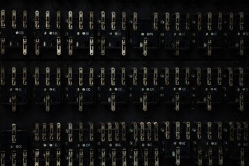 Old telephone control panel with tumblers and switches over black back