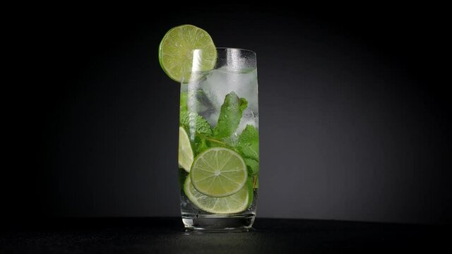 Mojito cocktail with ice on a black background.