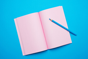 open notepad with empty pink sheets on a blue background