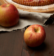 red ripe apples lies on a brown wooden table