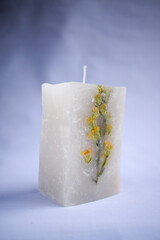 white decoration candle with a flower inside it with horizontal studio background