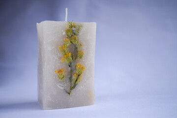 white decoration candle with a flower inside it with vertical studio background