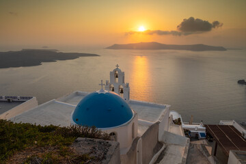 View of the sunset over the caldera, Catholic Church, Fira, Thira, Santorini, Greece.