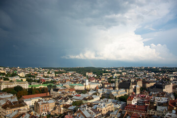 Fototapeta na wymiar Panorama of the city of Lviv under thick clouds with a sunny glimpse.