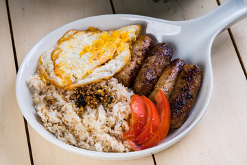skinless longanisa (pork or chicken meat) with fried egg; a staple food among Filipinos