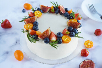 Top view on homemade vanilla birthday cake decorated with berries: strawberries, blueberries, figs on marble background. Celebration, party cake. Cake for holidays