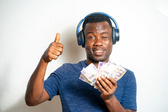  image of african guy, with bank note bit blurred, head phone- ghana cedis notes