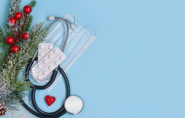 Christmas medical background. Stethoscope, medical mask, pills, heart, Christmas tree. Health concept in the context of coronavirus.Copy space fot text.Happy new year!