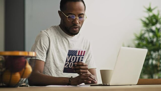 Handheld video of focused black man holding vote leaflet. Shot with RED helium camera in 8K.