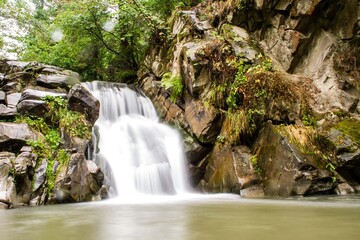 wodospad na rzece naturalny, rozmyta woda, zielone drzewa