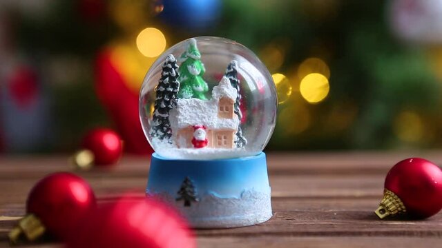 Christmas snow globe on background of christmas tree with christmas lights