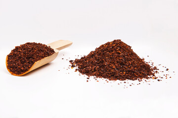 Red pepper in wooden spoon, ground red pepper isolated on white background.