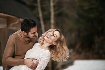 groom and bride walking in winter forest park. outdoors snowy day