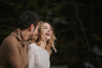 Fototapeta premium groom and bride walking in winter forest park. outdoors snowy day