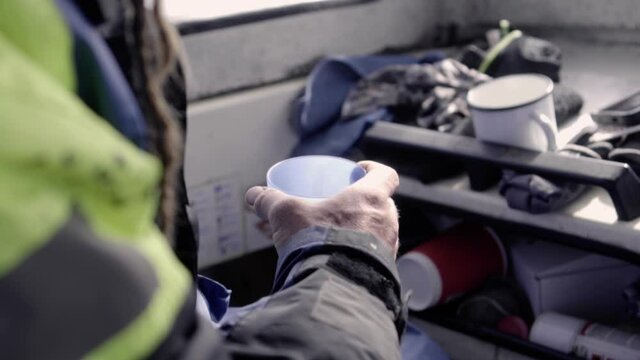 Sailer drinking his coffee inside a Swedish boat around Stockholm archipelago, SLOW-MO 120fps.