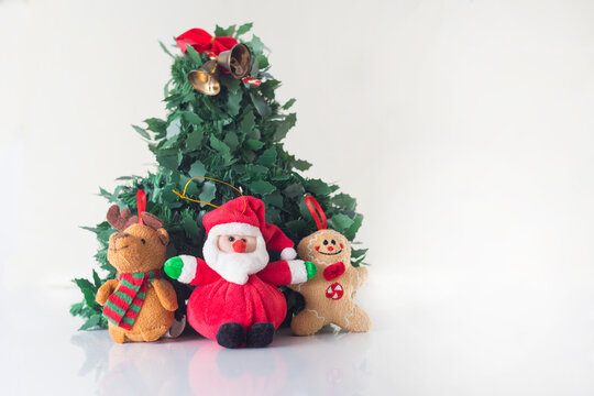 Christmas decorations next to Santa Claus have fun and play in a cup around a Christmas tree in the prosperity of the new year with white background