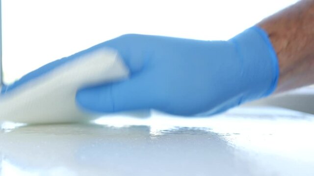 Close Up Man Hands with Blue Gloves Cleanse Furniture Surface Using Sprayed Cleaning Liquid