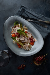 Close up on traditional italian cuisine Vitello tonnato. A dish with pickled veal with tuna cream sauce and bread on wooden background. Copy space for design, text. Snack before lunch. Close up food.